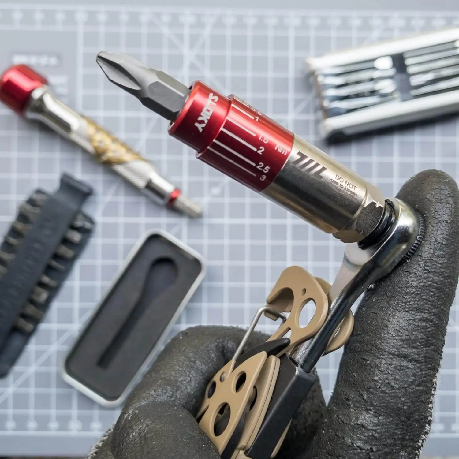 Gloved hand using the 711L Torque Driver HEXfits 12 mm socket on a multitool, demonstrating its compact and versatile precision for delicate assets   Dimensioned view of the 711L Torque Driver in red and silver with hash marks (0.5–3 Nm) for easy twist‑to‑set operation   Isolated shot of the 711L Torque Driver HEXfits 1/4” hex socket on a white background, showcasing its compact design and premium build   Gloved hand twisting the 711L Torque Driver on a Leatherman multitool, protecting your tools by achieving desired tightness without over‑torquing